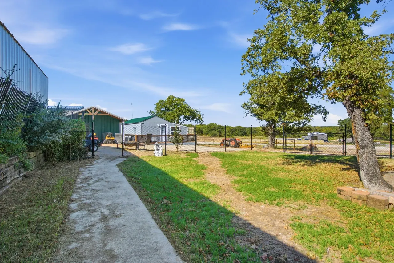 Concrete walkway along the side yard toward the outbuildings