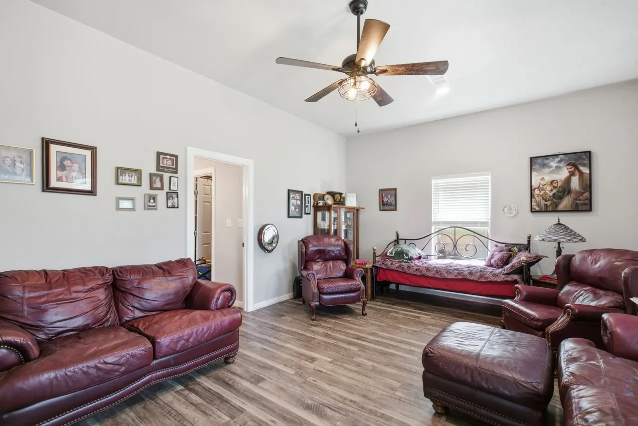 Den with burgundy leather sofas, an ottoman and a daybed