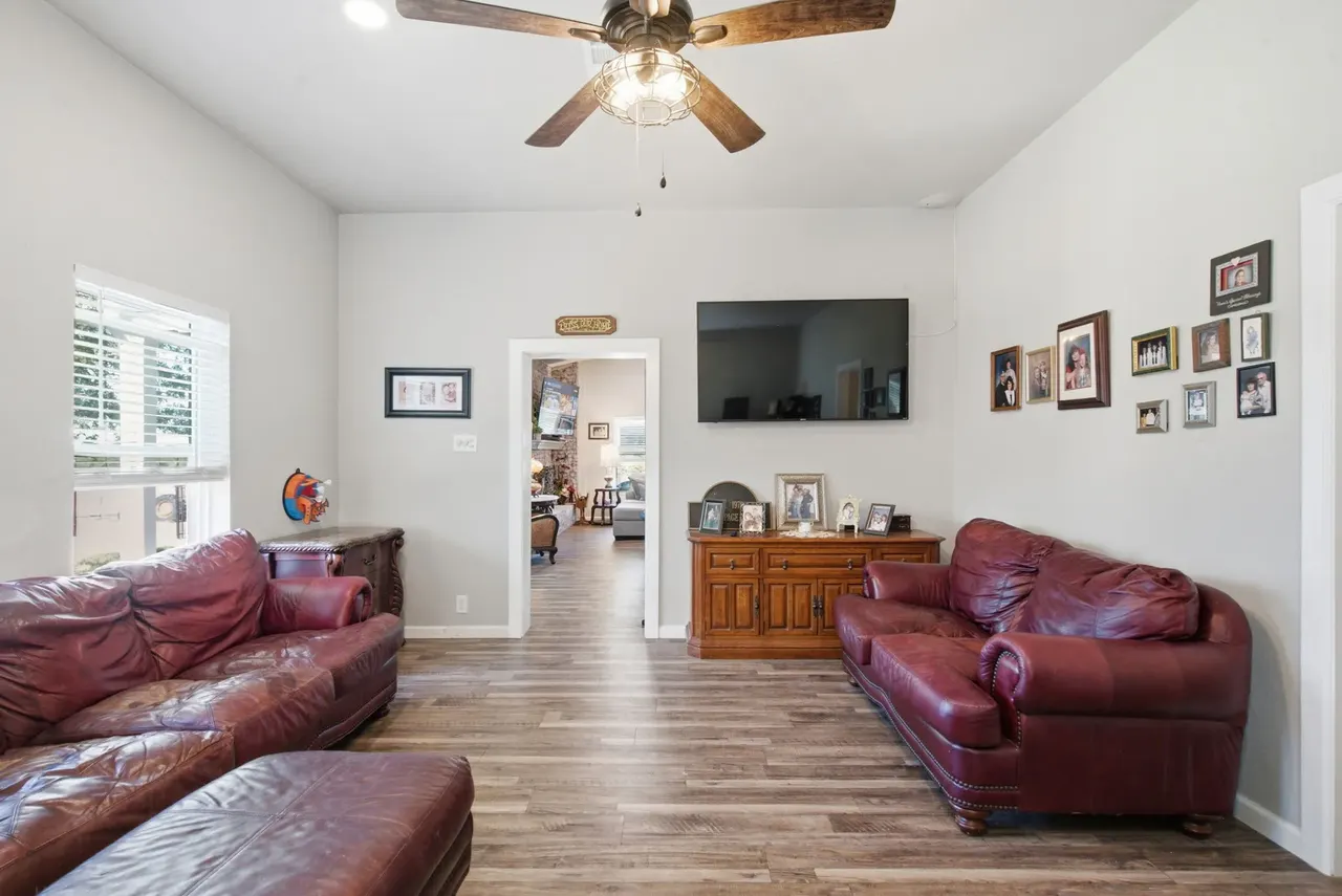 Den looking toward a wall-mounted TV and family photos