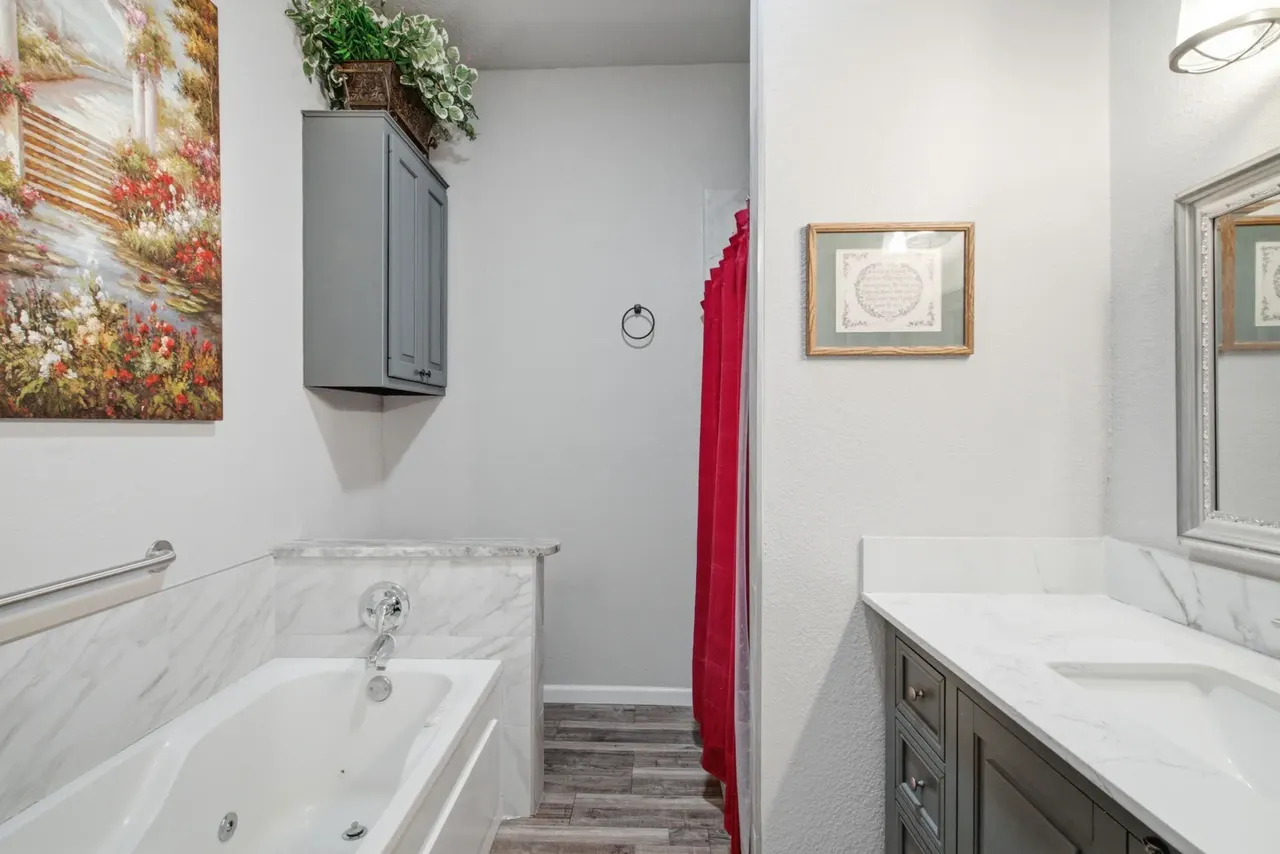 Primary bathroom with a jetted tub and grab bar