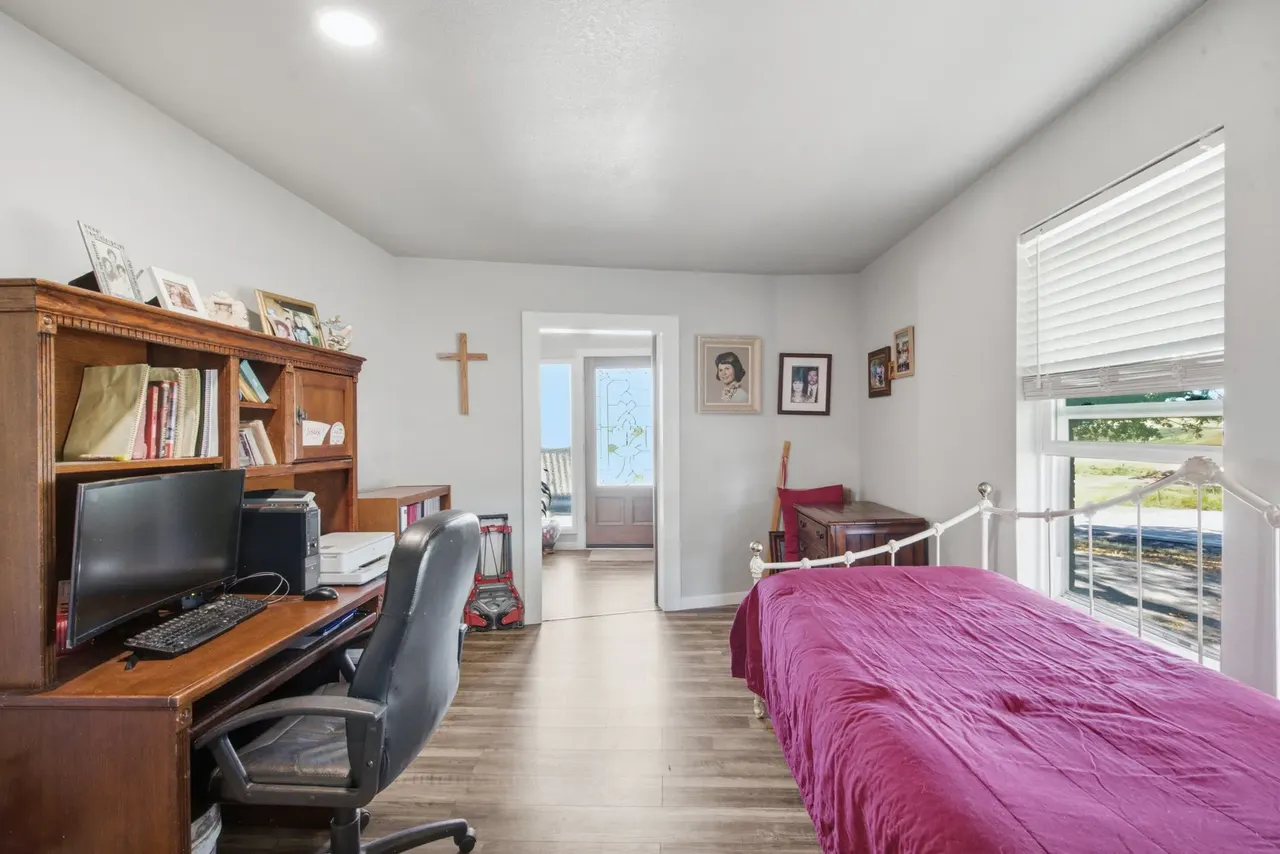 Office desk with a computer, bookshelves and the daybed beside it