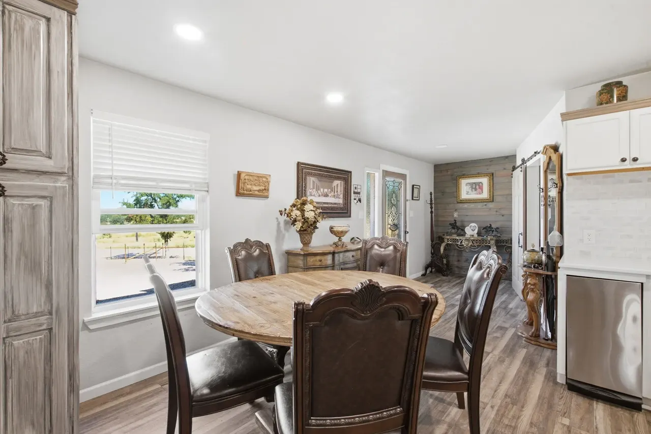 Dining nook with a round wooden table and chairs beside a window