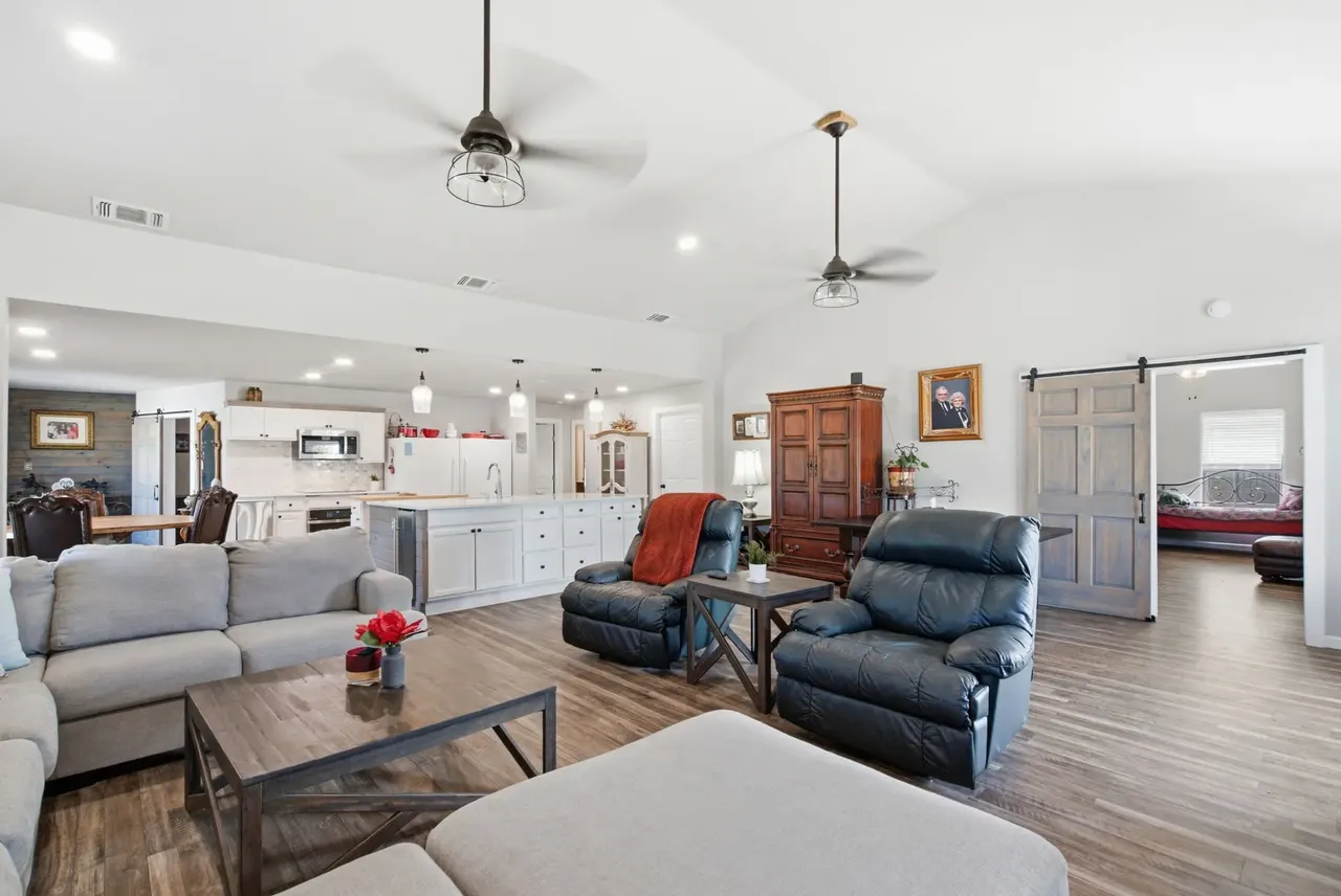 Open living area with leather recliners and a sliding barn door