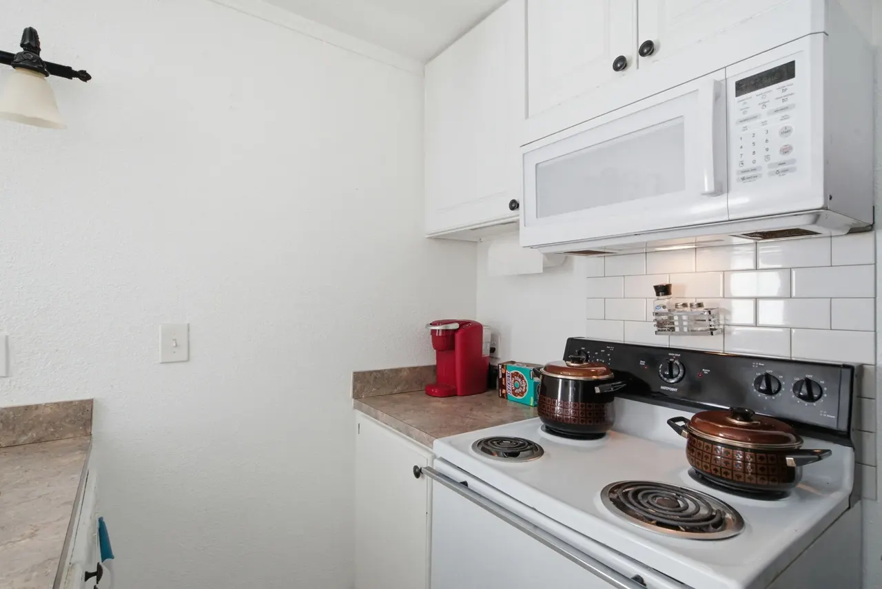 Cottage kitchen range with a microwave above and subway tile