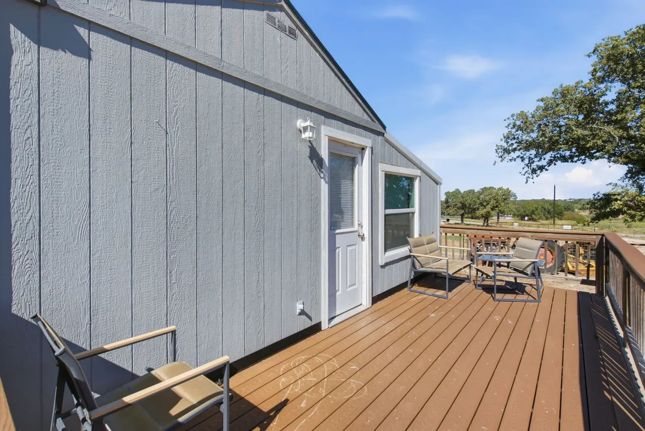Guest cottage deck with patio chairs and a view of the trees