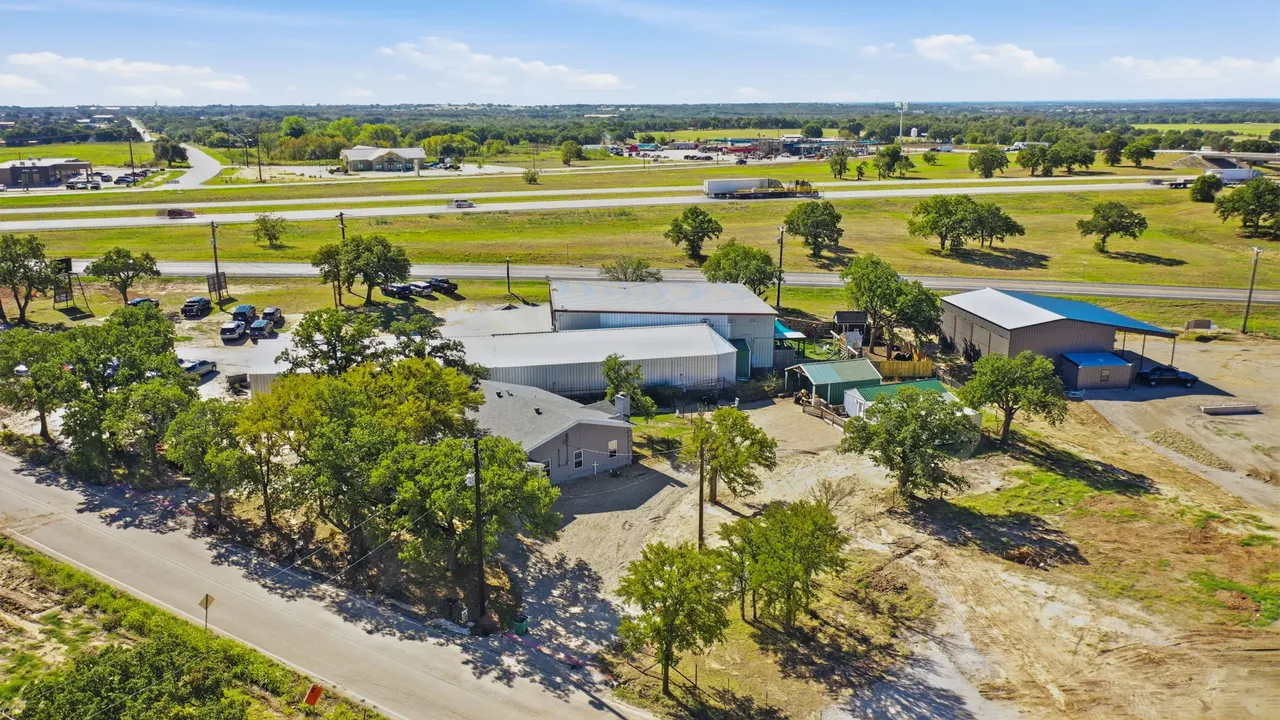 Aerial overview of the lot with the house, shop and cottage among oak trees