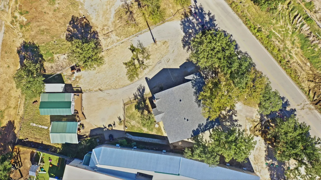 Straight-down aerial view of the house roof, outbuildings and trees
